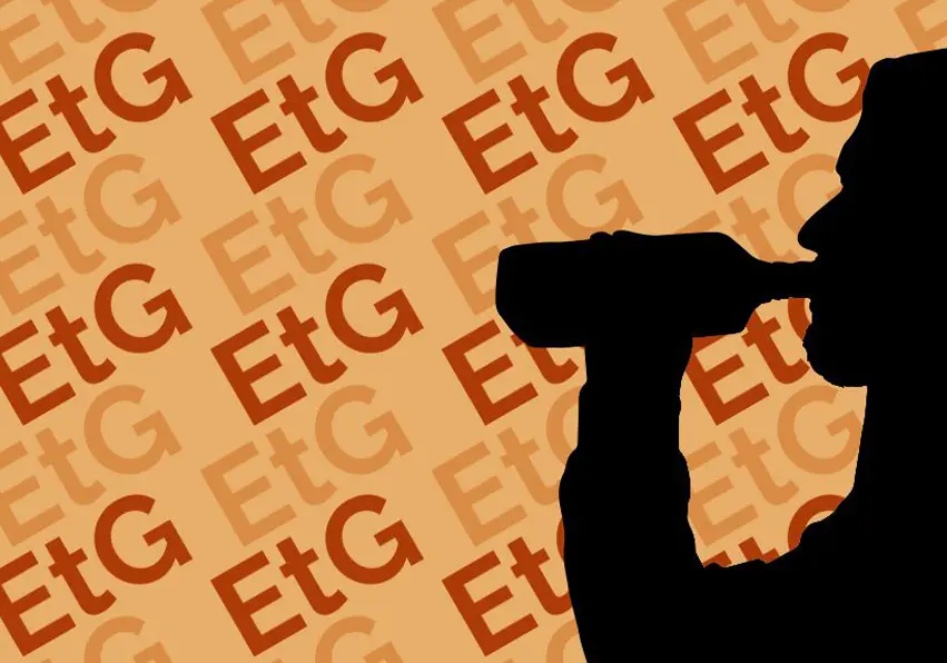 A silhouette of a person drinking from a bottle.
