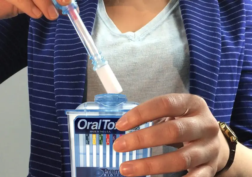 A woman holding an oral-b toothbrush in her hand.